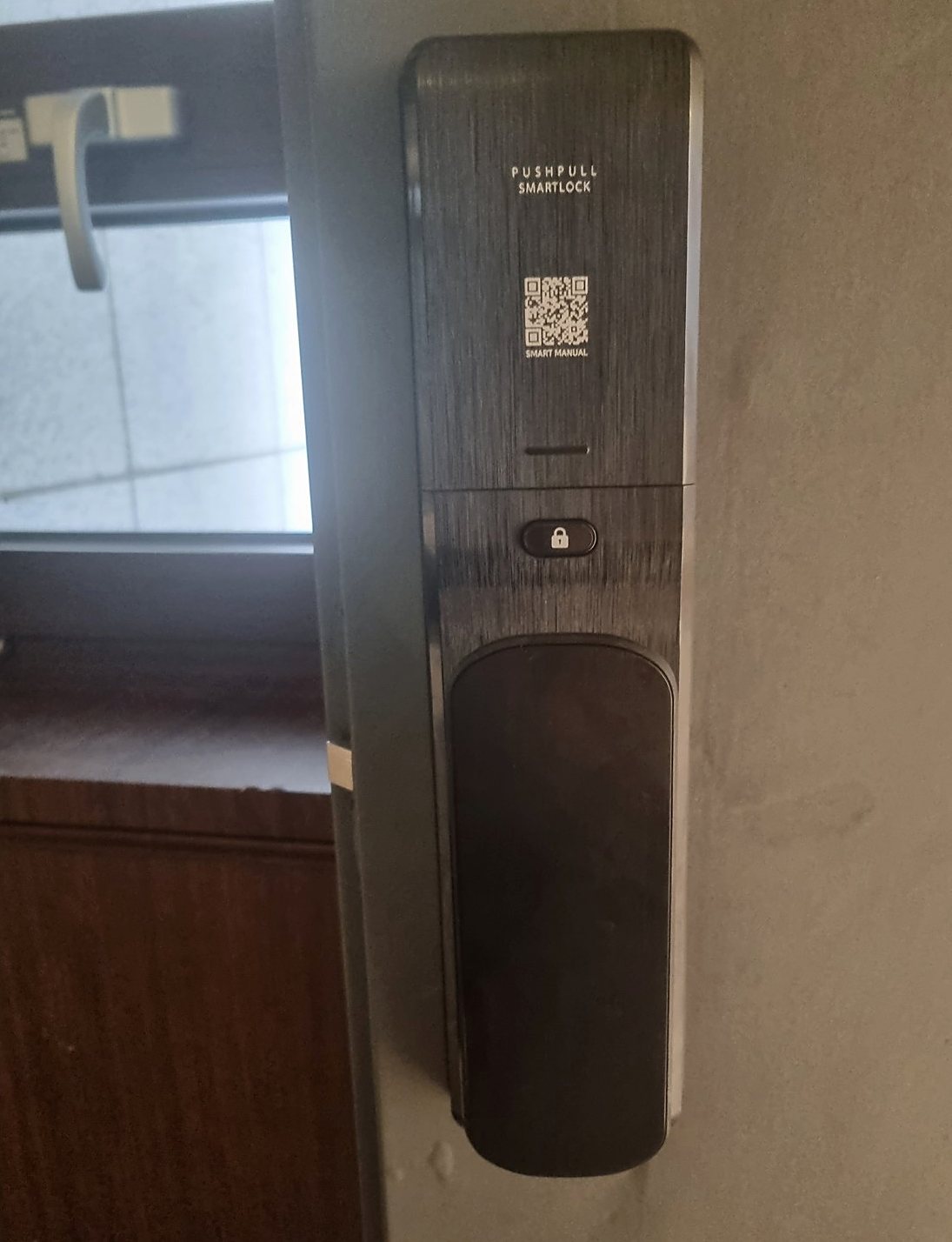 도봉구 창제2동 출장 — 회색 문에 단 긴 검은 푸시풀 도어락 본체, 위쪽 QR 표시와 가운데 잠금 버튼